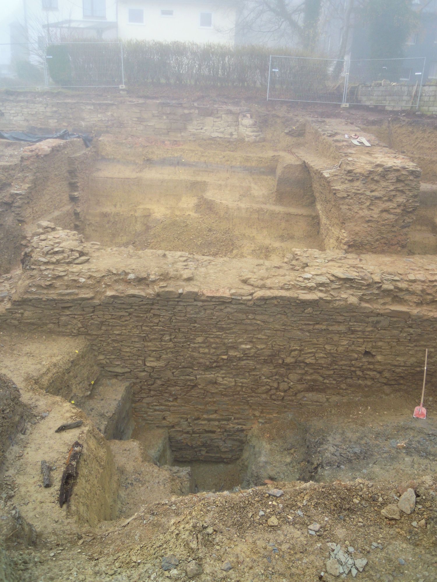 10.11.2020: Die 4 m hohe Mauer (im Vordergrund) wurde bis zum Fundament freigelegt. Die graue Färbung des Bodens (rechts) sind Überreste eines Wassergrabens.